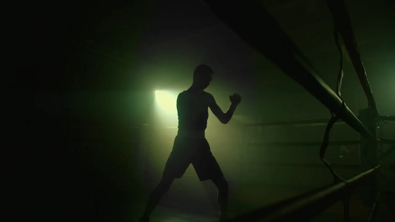 Silueta de un boxeador entrenando a contraluz verde